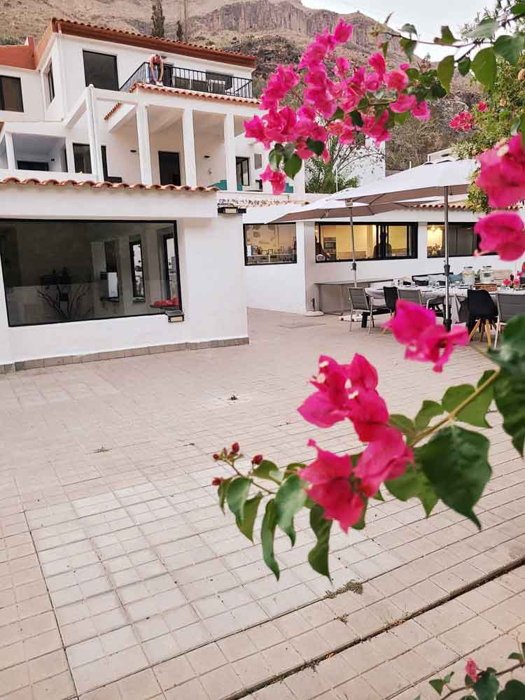 Aya House courtyard framed by vivid bougainvillea and mountain rock
