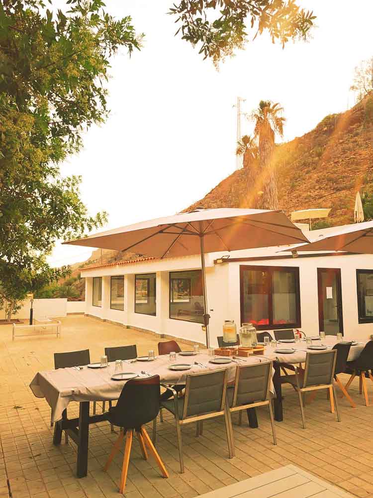 A long outdoor dining table prepared for a shared meal